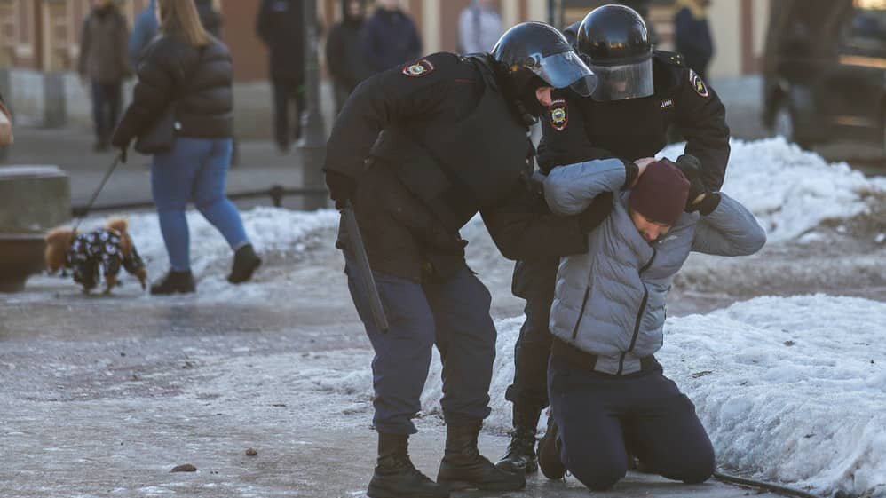 Agentes de policía detienen a un manifestante durante una protesta contra la operación militar rusa en Ucrania.