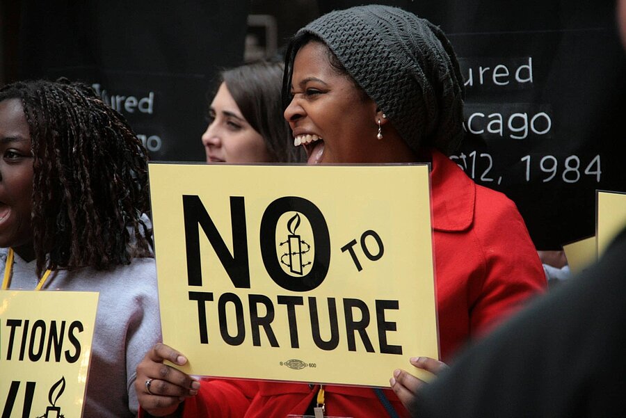 Activistas de Amnistía Internacional se manifiestan junto a supervivientes de tortura durante la conferencia sobre derechos humanos que tuvo lugar...