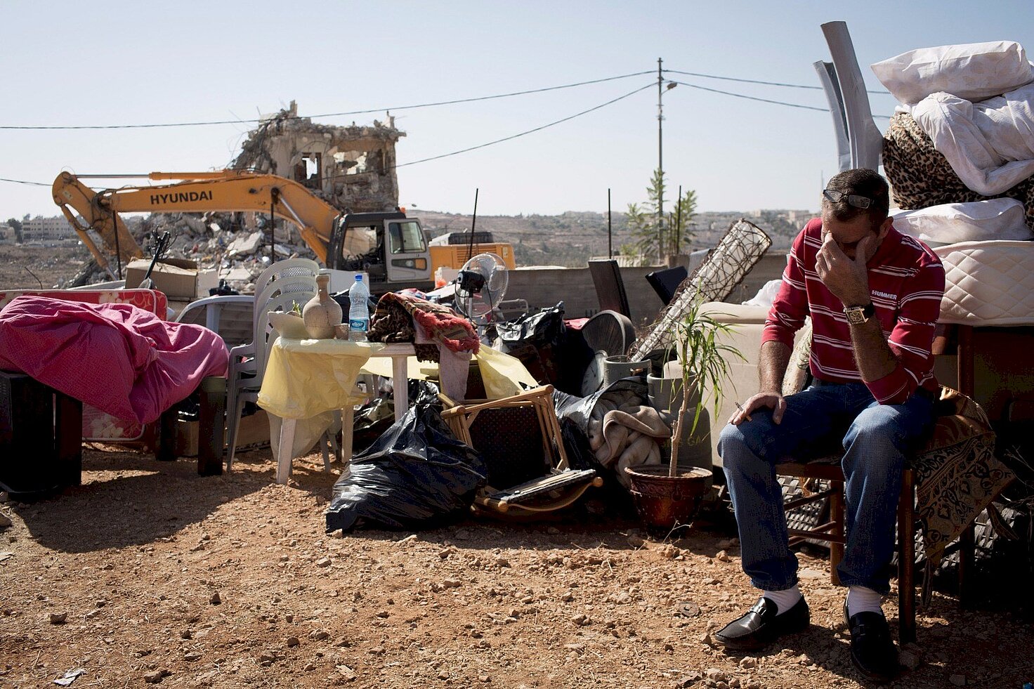 Un hombre palestino se lamenta junto a su casa demolida por excavadoras israelíes