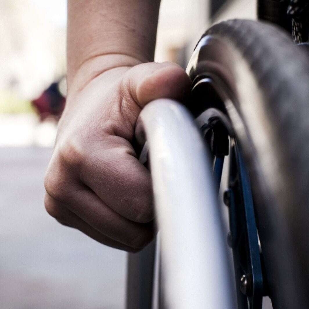 Una mano manejando una silla de ruedas