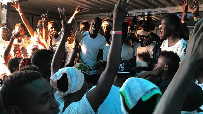Alegría de las personas migrantes rescatadas en la cubierta del buque de salvamento Ocean Viking. 