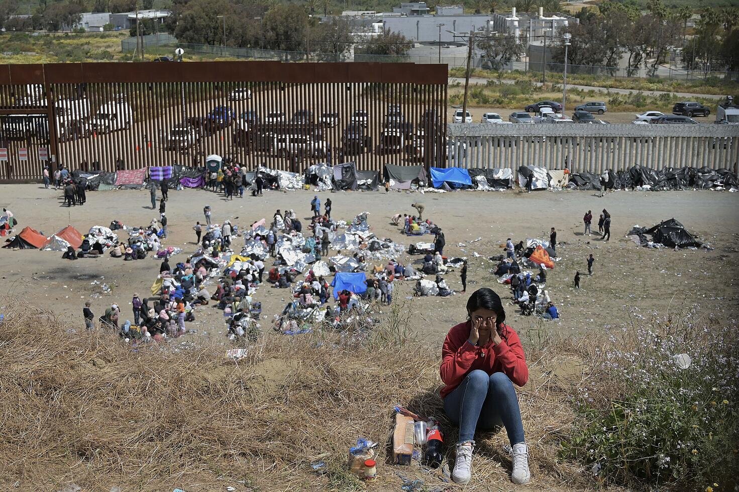 Una mujer se tapa la cara frente al muro de la frontera con Estados Unidos en la localidad de Tijuana-San Diego