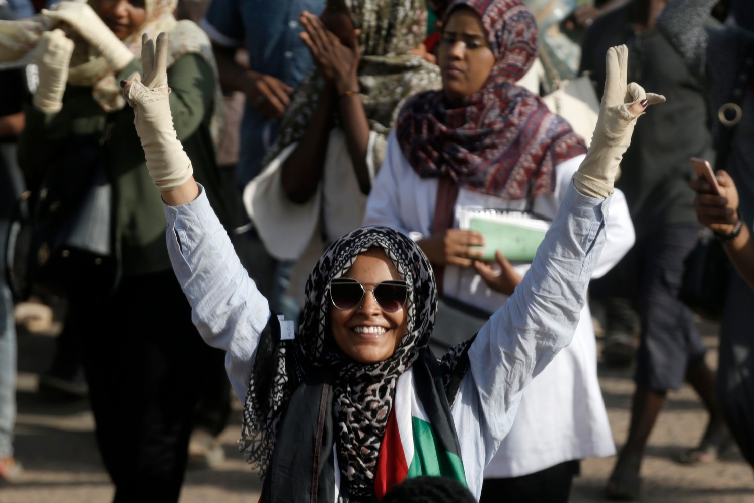 Una mujer muestra el signo de la victoria mientras se manifiesta en Jartum