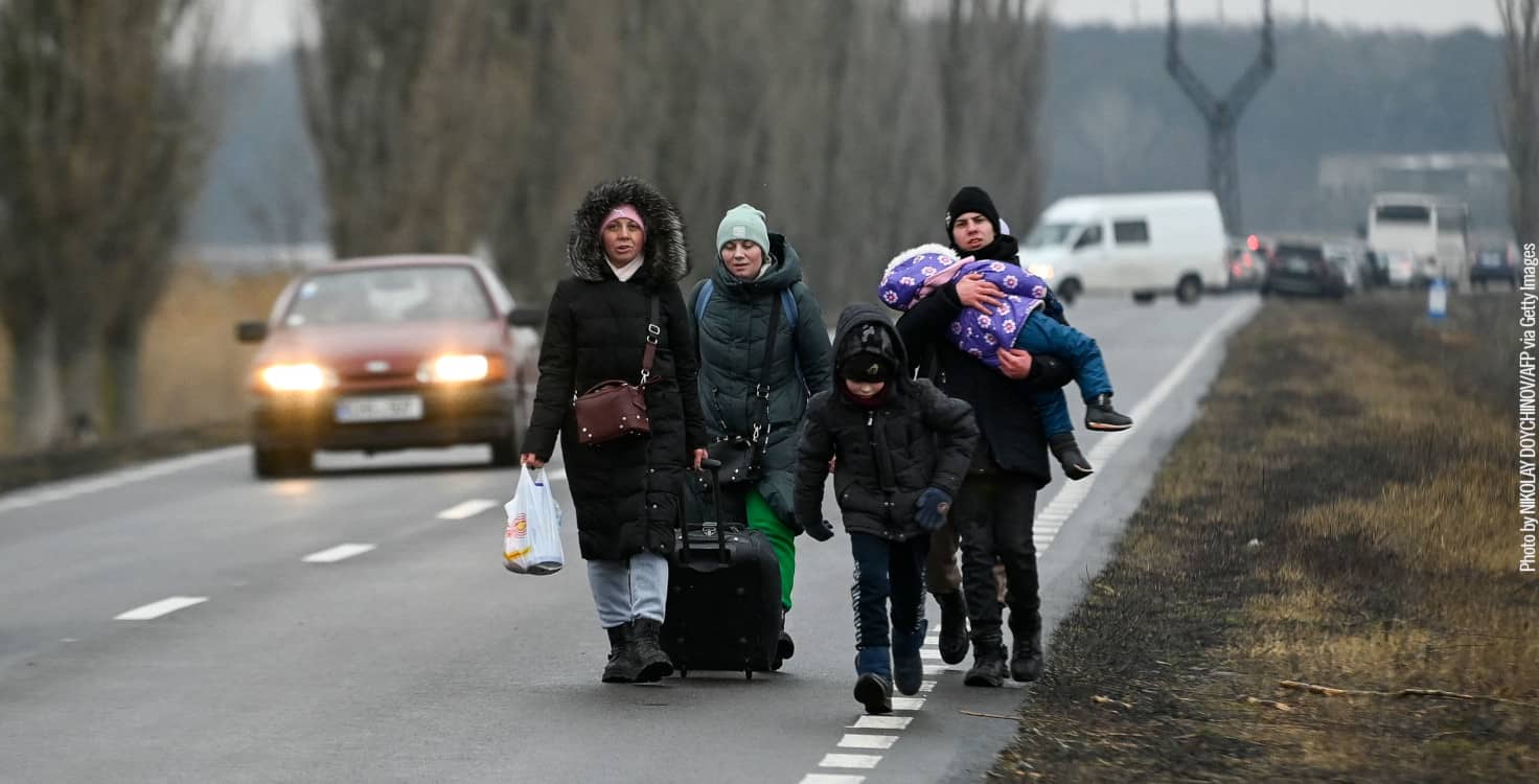 Varias personas refugiadas caminan por una carretera 