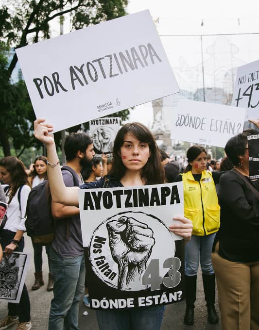 joven con pancarta que dice Ayotzinapa dónde están