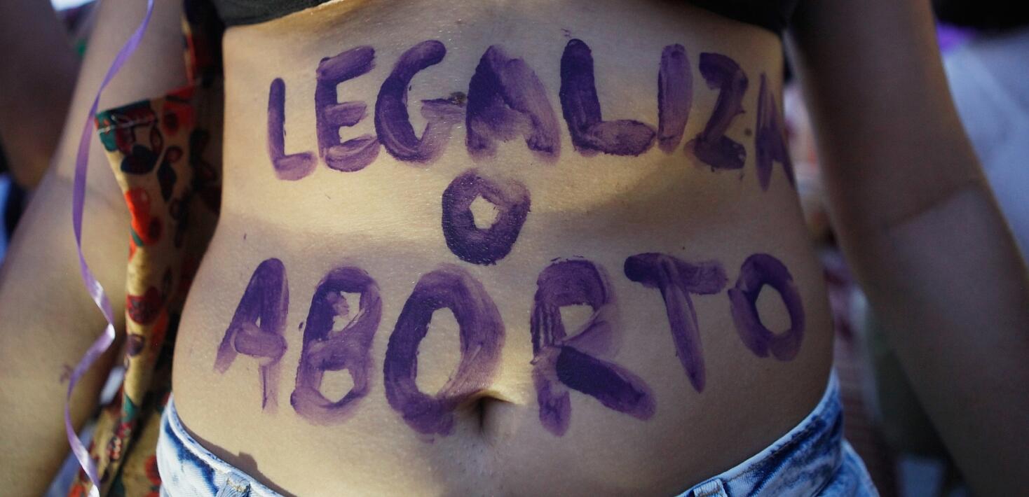 Una manifestante con el lema "legalización del aborto" escrito sobre su tripa