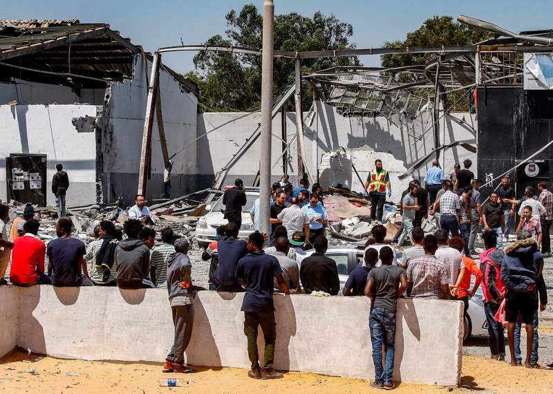 Migrantes congregados ante un centro de detención de Tajoura (Libia) en julio, tras un ataque aéreo contra un edificio cercano en el que murieron...
