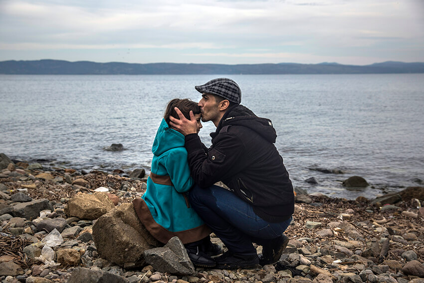 Un hombre sirio besa a su hija poco después de desembarcar de un bote en una playa de la isla griega de Lesbos tras cruzar el mar Egeo desde la costa turca. En el Día Internacional del Beso, AmnistIa recuerda la necesidad de proteger los derechos de las personas refugiadas